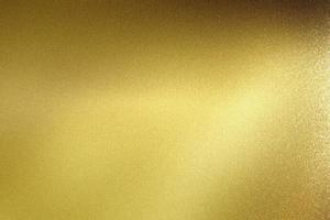 Glowing polished golden metal wall, abstract texture background photo