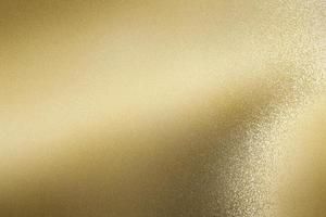 Glowing brushed gold foil metallic sheet, abstract texture background photo