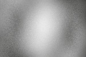 Glowing rough silver metal wall surface, abstract texture background photo