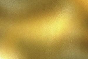 Light shining on rough gold metal plate, abstract texture background photo