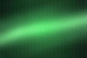 Light shining on green metallic plate in dark room, abstract texture background photo