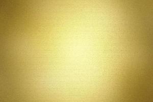 Light shining on brushed gold metal wall texture, abstract background photo