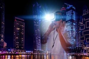 Defocus overlapping image of a man wearing virtual reality glasses and a modern building. Metaverse digital cyber technology concept. Future digital technology cyber virtual game entertainment. photo