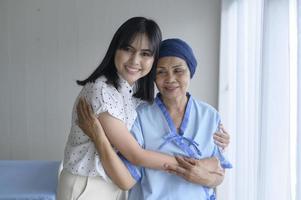 Cancer patient woman wearing head scarf and her supportive daughter in hospital, health and insurance concept. photo
