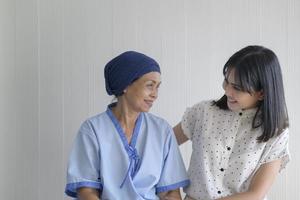 Cancer patient woman wearing head scarf and her supportive daughter in hospital, health and insurance concept. photo