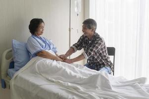 Senior man visiting senior patient woman at hospital, health care and medical concept photo