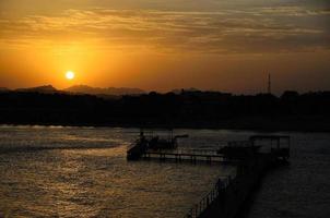 puesta de sol con un mar de embarcadero foto