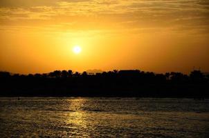 puesta de sol en el mar con palmeras foto