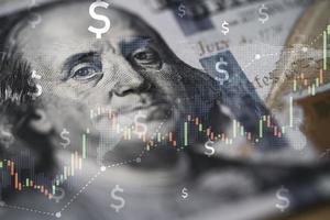 Closeup Benjamin Franklin face on USD banknote with stock market chart graph for currency exchange and global trade forex concept. photo