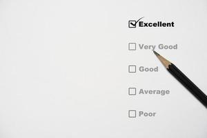 matriz de lápiz negro en la hoja de encuesta que marca un resultado excelente para la evaluación del cliente después de usar el concepto de producto y servicio.