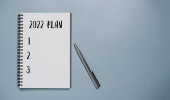 Plan 2022 en cuaderno con bolígrafo para preparar un nuevo plan de negocios y objetivo de año nuevo.