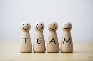 Wooden figures smile face with team wording on body for teamwork and business corporation concept. photo