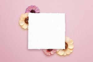 Clean paper for greeting text surrounded by spring flowers photo
