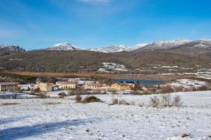 snowy mountain landscape with lake and village photo