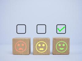 happy smiley face in wooden block with check mark for feedback rating and positive customer review photo