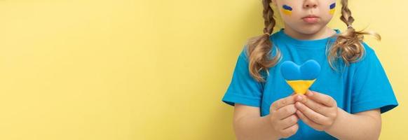 la chica tiene un corazón de color amarillo y azul de la bandera ucraniana. banner con espacio de copia foto