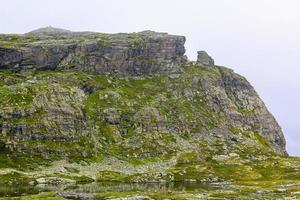 Fog, clouds, rocks, cliffs on peak of Veslehodn Veslehorn. photo