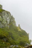 niebla, nubes, rocas y acantilados en veslehodn veslehorn mountain, noruega. foto