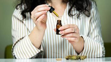 Close-up of unrecognizable woman using and holding medical cannabis oil. photo