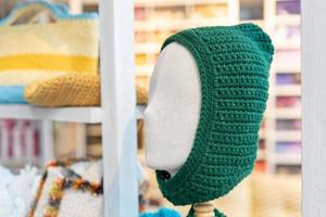 gorro de punto de lana verde. sombrero de punto verde en la cabeza del maniquí foto
