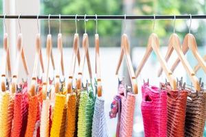 a lot of multi-colored knitwear on a rack in the showroom. Background of knitted things of different colors. The texture of knitted clothing. Handmade work and home hobbies. photo