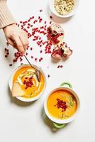 pumpkin soup served with squash and pomegranate seeds photo