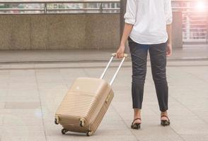 Businesswoman traveler with luggage at city background photo