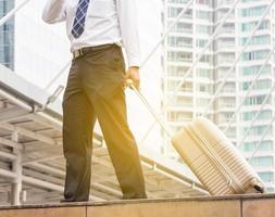 Businessman traveler with luggage at city background photo