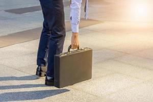 Young business man standing with his back carrying a briefcase city background, Start and forward Concept. photo