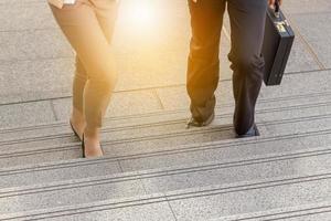 hombre de negocios y mujer de negocios subiendo escaleras con bolsas a la oficina.