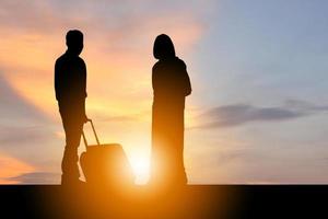 Silhouette of young man and woman traveler with luggage suitcases, travel concept photo