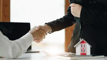 Estate agent shaking hands with customer after contract signature photo