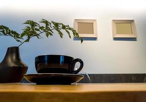 Coffee cup on wood table with fern leaf photo