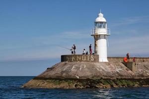 BRIXHAM, DEVON, UK, 2012. People fishing near the lighthouse photo