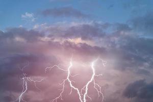 Lightning strikes between gloomy stormy clouds. photo