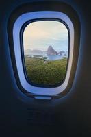 imagen conceptual de turismo y transporte, ventana del avión con vista de ariel de samed nang shee en tailandia. foto