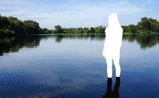 suicide or death by drowning concept with human figure standing in water photo