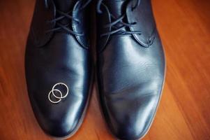 zapatos de hombre negro y anillos de boda