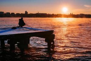 People on the pier watching the sunset photo