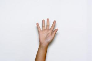 Boy raising five fingers up on hand on white background. photo