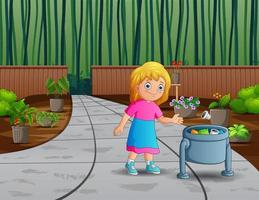 una niña tira basura en la basura del jardín vector