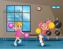 Two cute girls practicing cheerleading in gym vector