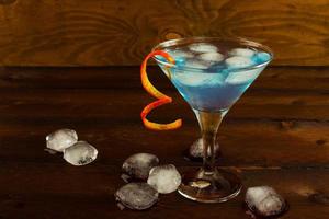 Blue Martini cocktail on the dark wooden background photo