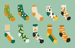 conjunto moderno de calcetines de colores brillantes aislados en fondo verde. calcetines con diferentes estampados abstractos. ilustración de dibujos animados de vectores