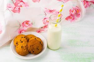 Milk and cookies on white plate photo