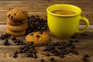 Yellow mug of strong coffee and cookies photo