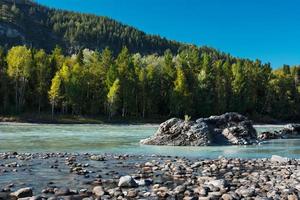 Rocky shore of the turquoise river photo