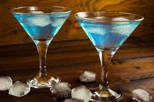 Two blue cocktails in glasses on dark wooden background photo