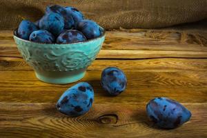 plum prunes in a turquoise cup photo