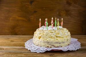Birthday meringue cake with burning candles photo